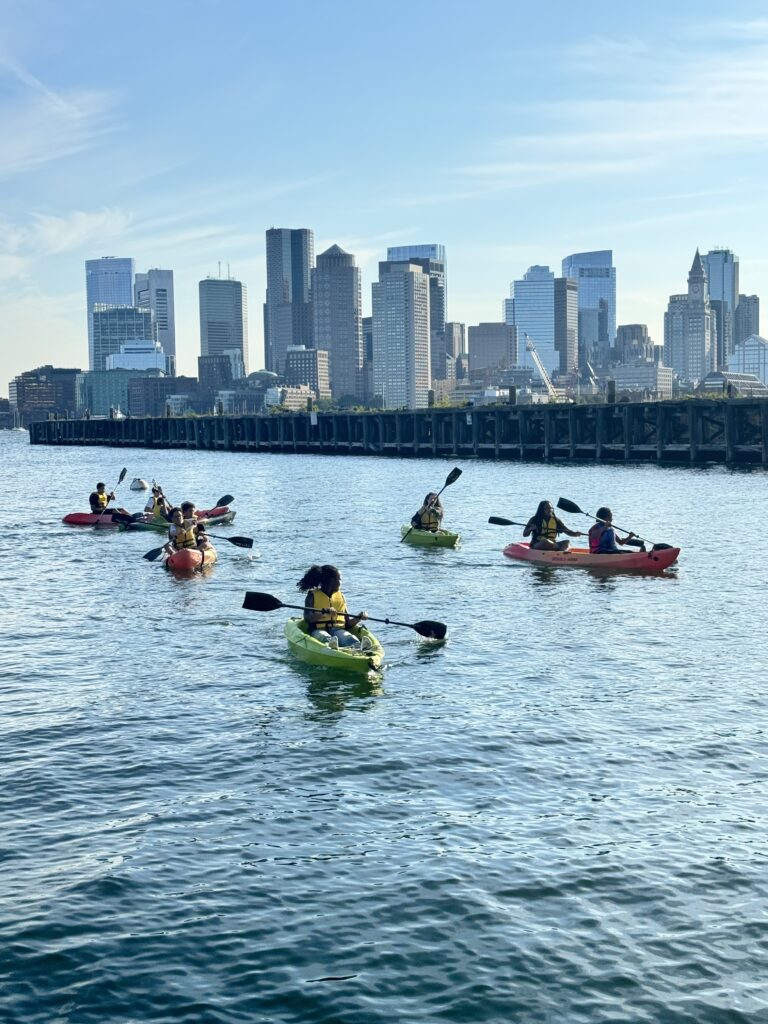 Kakayers in the Piers Park cove with the Boston skyline in the background.
